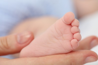 Photo of Mother with her little baby on bed indoors, closeup