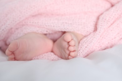 Photo of Little baby lying on bed indoors, closeup