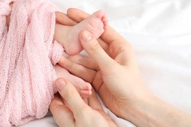 Photo of Mother with her little baby on bed indoors, top view