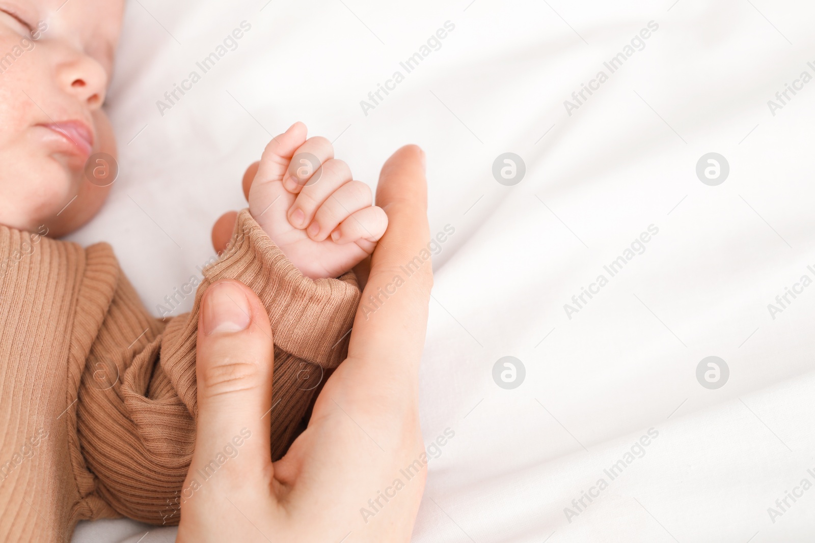 Mother with her little baby on bed indoors, closeup. Space for text Photo of Mother with her little baby on bed indoors, closeup. Space for text