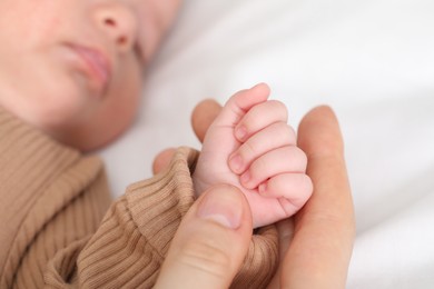 Photo of Mother with her little baby on bed indoors, closeup