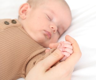 Photo of Mother with her little baby on bed indoors, closeup