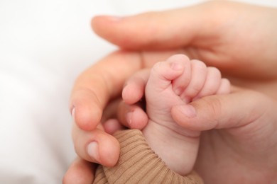 Photo of Mother with her little baby on bed indoors, closeup