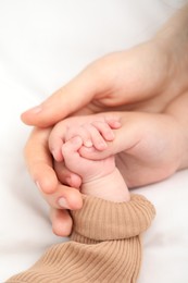 Photo of Mother with her little baby on bed indoors, closeup