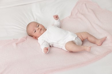 Photo of Cute little baby lying on bed at home, above view