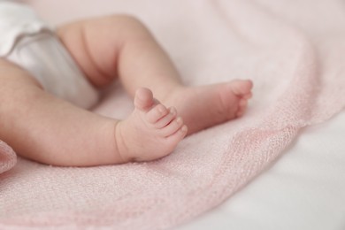 Photo of Cute little baby lying on bed at home, closeup