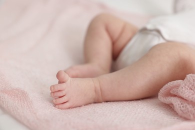 Photo of Cute little baby lying on bed at home, closeup