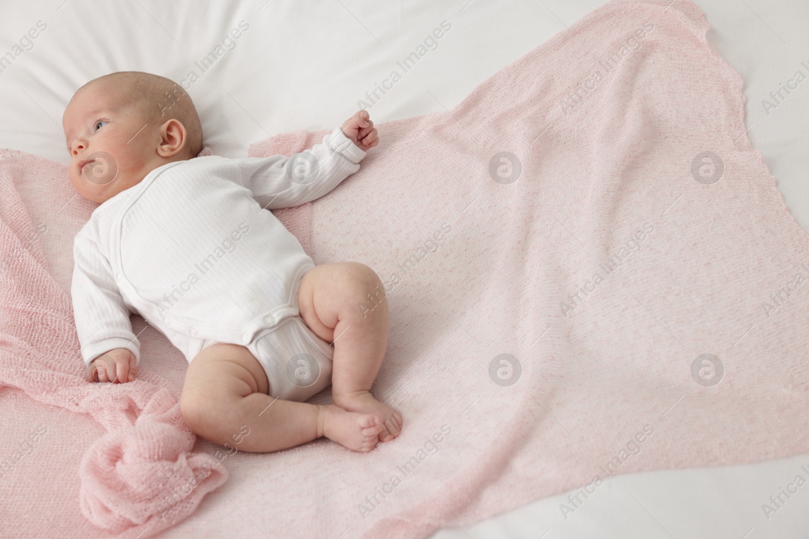 Cute little baby lying on bed at home, above view. Space for text Photo of Cute little baby lying on bed at home, above view. Space for text
