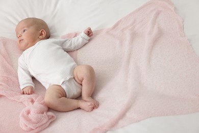 Photo of Cute little baby lying on bed at home, above view. Space for text