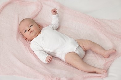 Photo of Cute little baby lying on bed at home, above view