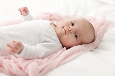 Photo of Cute little baby lying on bed at home