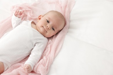 Photo of Cute little baby lying on bed at home, space for text