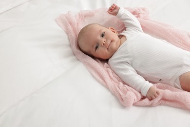 Photo of Cute little baby lying on bed at home, space for text