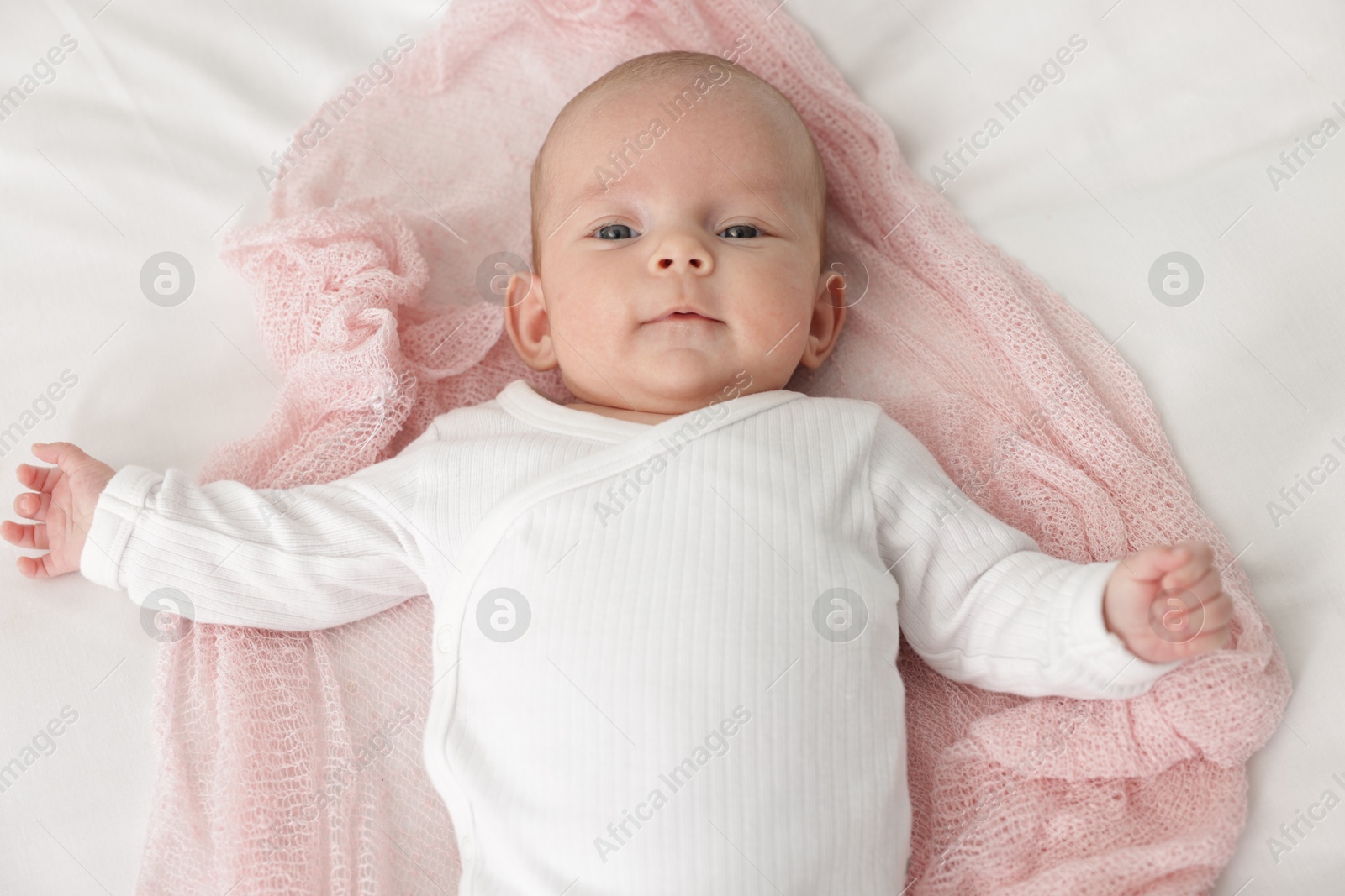 Cute little baby lying on bed at home, top view Photo of Cute little baby lying on bed at home, top view