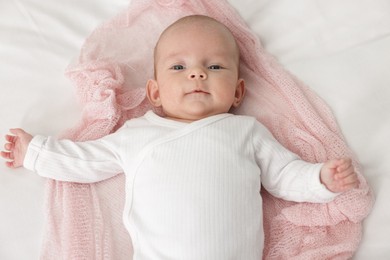 Photo of Cute little baby lying on bed at home, top view