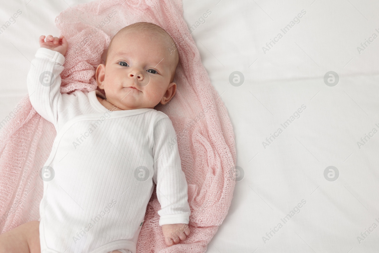 Cute little baby lying on bed at home, top view. Space for text Photo of Cute little baby lying on bed at home, top view. Space for text