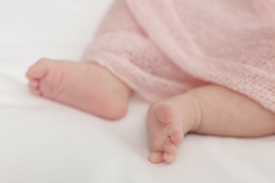 Photo of Cute little baby lying on bed at home, closeup