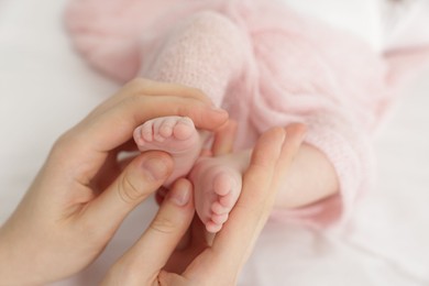 Photo of Mother with her little baby on bed indoors, closeup