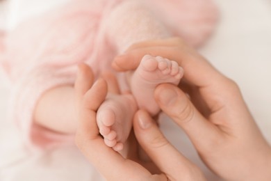 Photo of Mother with her little baby on bed indoors, closeup