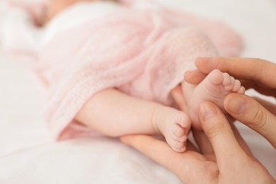 Photo of Mother with her little baby on bed indoors, closeup