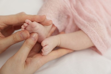 Photo of Mother with her little baby on bed indoors, closeup