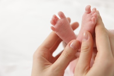 Photo of Mother with her little baby on bed indoors, closeup. Space for text