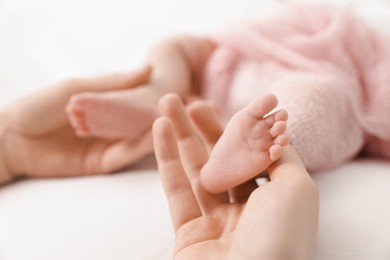 Photo of Mother with her little baby on bed indoors, closeup