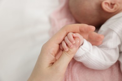 Photo of Mother with her little baby on bed indoors, closeup. Space for text