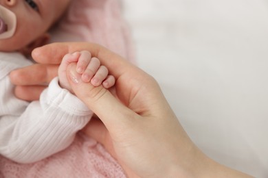 Photo of Mother with her little baby on bed indoors, closeup. Space for text