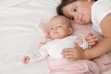 Photo of Cute girl and her little sister on bed at home, space for text