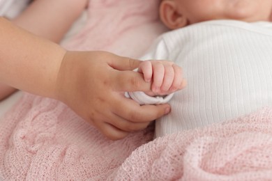 Photo of Cute girl and her little sister on bed at home, closeup