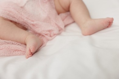 Photo of Cute little baby lying on bed at home, closeup. Space for text
