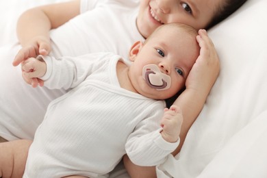 Photo of Cute girl and her little sister on bed at home, selective focus