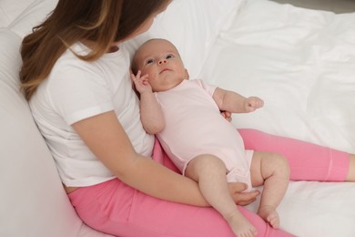 Photo of Cute girl and her little sister on bed at home, closeup