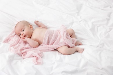 Photo of Cute little baby lying on bed at home, space for text