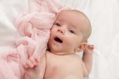 Photo of Cute little baby lying on bed at home