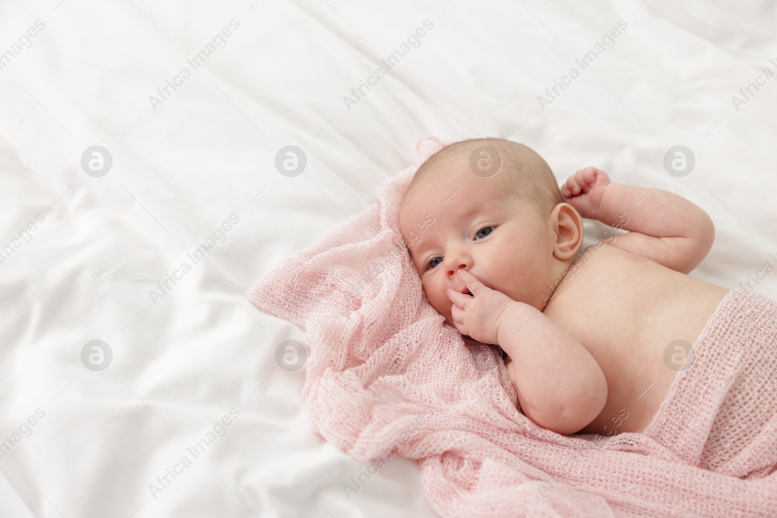 Cute little baby lying on bed at home, space for text Photo of Cute little baby lying on bed at home, space for text