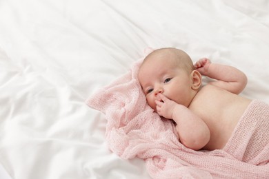 Photo of Cute little baby lying on bed at home, space for text