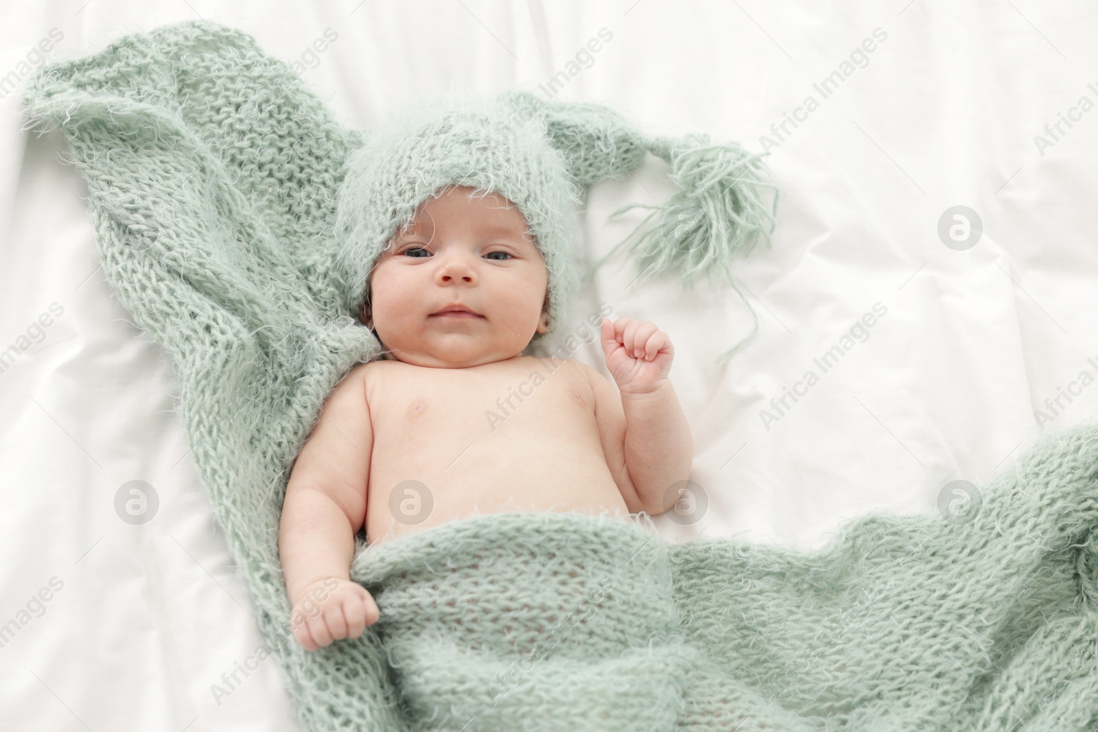 Cute little baby lying on bed at home, top view Photo of Cute little baby lying on bed at home, top view
