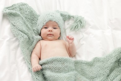 Photo of Cute little baby lying on bed at home, top view