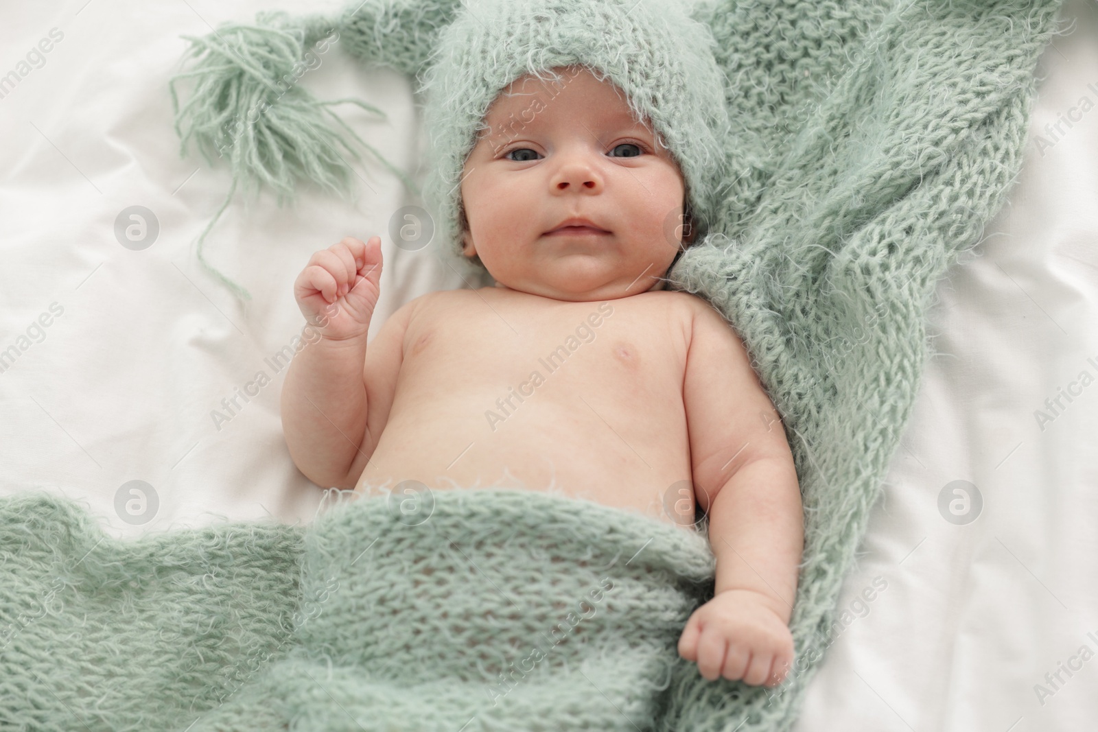 Cute little baby lying on bed at home, top view Photo of Cute little baby lying on bed at home, top view