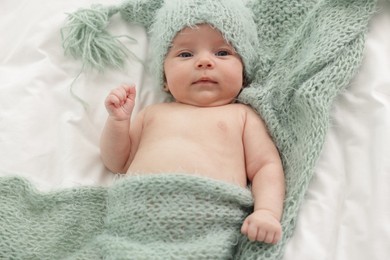 Photo of Cute little baby lying on bed at home, top view