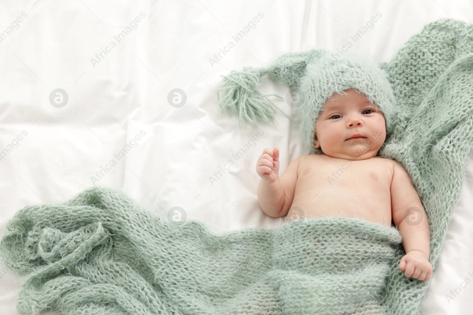 Cute little baby lying on bed at home, top view. Space for text Photo of Cute little baby lying on bed at home, top view. Space for text