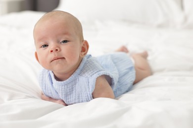 Photo of Cute little baby on bed at home, space for text