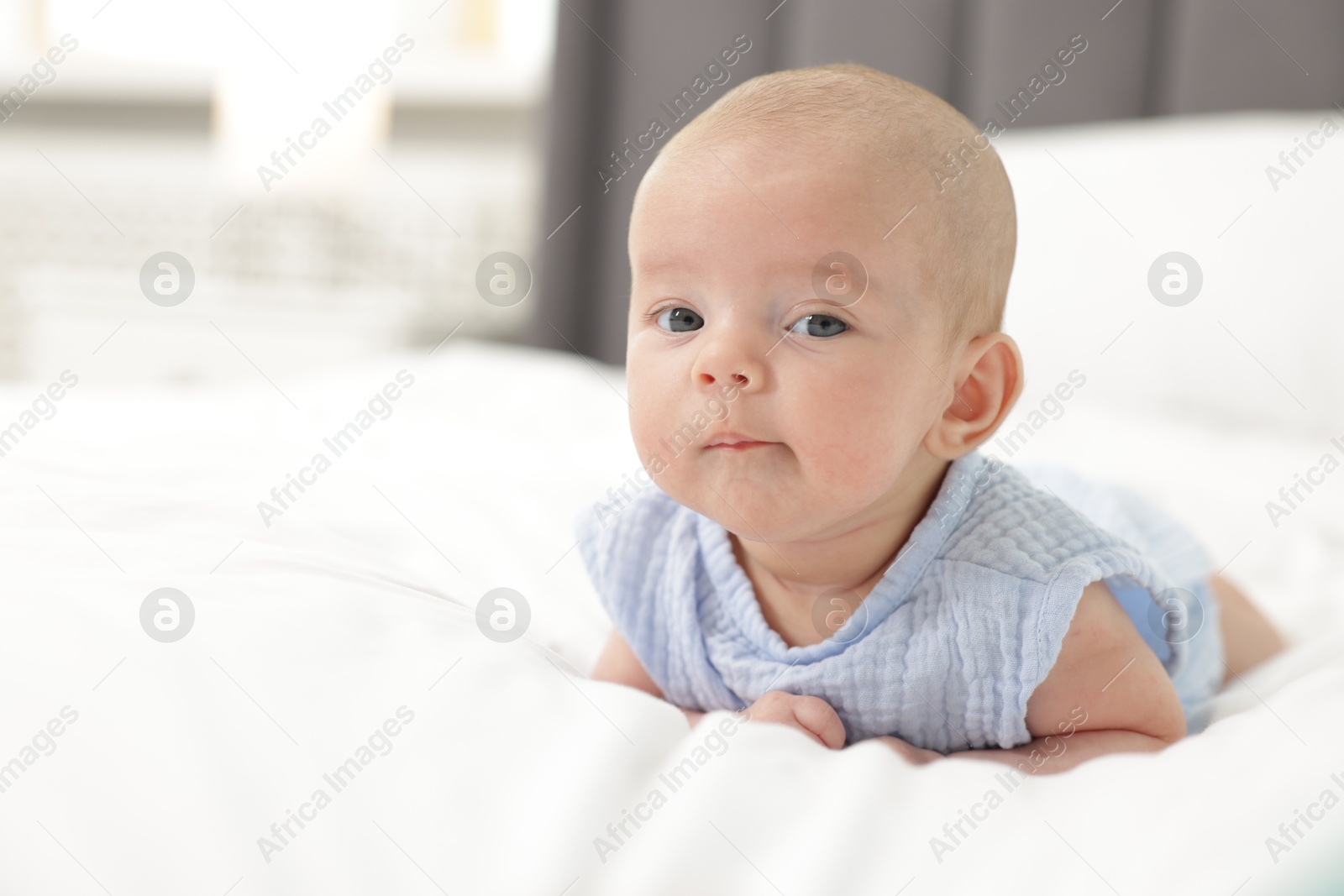 Cute little baby on bed at home, space for text Photo of Cute little baby on bed at home, space for text