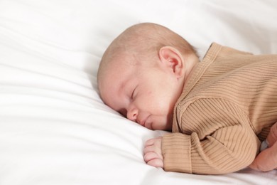 Photo of Cute little baby sleeping on bed at home. Space for text