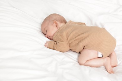 Photo of Cute little baby sleeping on bed at home. Space for text
