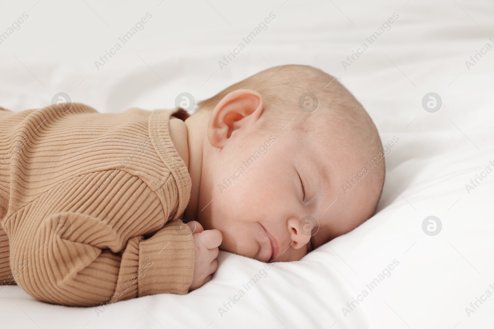 Cute little baby sleeping on bed at home Photo of Cute little baby sleeping on bed at home