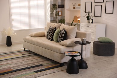 Photo of Comfortable sofa with cushions in room. Interior design