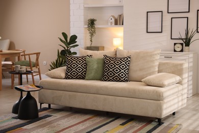 Photo of Comfortable sofa with cushions in room. Interior design
